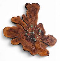 Top down view of the thick slab burl clock showing rich wood grain, varnish finish, and Roman numeral hour markers.