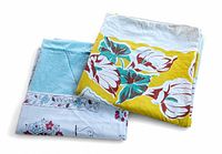 Photo of two folded vintage tablecloths, one blue and one yellow, showing colors and patterns.