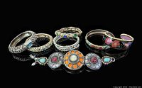 Photo showing the seven vintage costume jewelry pieces including bangles and a decorative bracelet with stones, enamel, and metalwork.