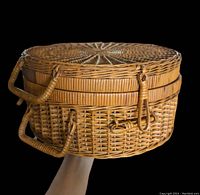 Front view of the large round wicker basket with lid and handles, showing side toggle missing.