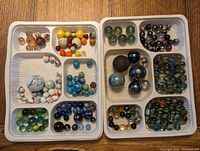 Top view of both trays showing a variety of vintage glass marbles in multiple compartments. Marbles of diverse colors and sizes are displayed in white plastic segmented trays.
