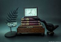 Photo showing full lot including black metal leaf-shaped tea light holder with glass insert, 3 vintage books including 2 Charles Dickens and 1 Mrs Henry Wood, carved wood bird sculpture, MCM Westclox clock on wooden box.