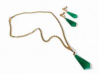 Gold tone necklace laid flat with matching green stone screwback earrings beside it. Pendant and earrings geometric shapes, pendants mounted on gold tone metal.