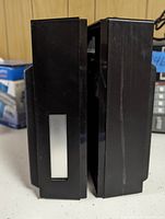 Side view of the black plastic shrouds covering the speakers containing volume control and 8 track player