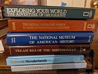 Stack of six hardcover books showing titles and publishers on spines.