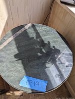 Full view of round table top with a green granite or granite-like surface and a blue tape label 'CP10'.