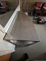 Top view photo showing smooth stainless steel surface top shelf reflecting light and room elements.