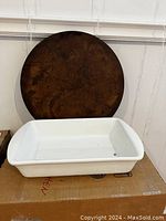 Photo showing the white rectangular baking dish in front of the round pizza stone.