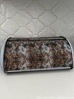 Front view of metal breadbox showing the detailed floral and ornamental decoupage design on chalk painted surface.
