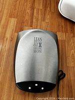 Top view of the closed electric meat grill showing stainless steel finish with text 'Lean Mean Fat Grilling Machine'.