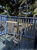 One tall decorative metal plant stand with two circular shelves in gray finish.