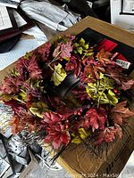 Fall wreath with red and orange maple leaves on table