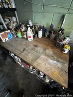 Photo showing the butcher block top surface with visible wear, stains, and various containers on top (not included).