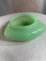 Photo of vintage Fenton jadeite triangular candy bowl showing top opening and glossy pale green glass surface.