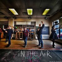 Group of participants throwing axes down marked lanes in a bar lounge setting with 'In The Air Legacy' floor branding