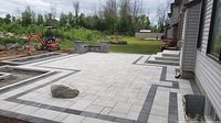 Grey and charcoal interlock patio installation with seating wall and retaining features