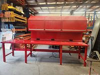 Front view of full workbench showing three overhead cabinets, solid steel top, and power outlets.