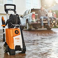 Front view of orange and white pressure washer on driveway