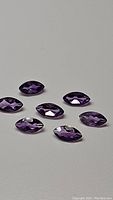 Eight marquis cut deep purple Brazilian amethyst stones displayed on a plain background, showing size and cut.