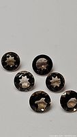 Six round diamond cut natural smokey quartz gemstones arranged on a flat surface, showing their facets and clarity.