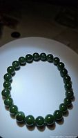 Overhead photo of Canadian jade bead bracelet showing round green beads on white background