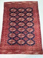 Full view of the Persian Baluch wool rug showing its overall pattern, colors, and condition.