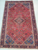 Full view of rug showing diamond medallion pattern with red field and blue corner triangles