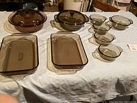 Full view of the baking ware set including rectangular, round casserole dishes with lids and small glass bowls.