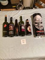 Overview of six empty band memorabilia bottles and one collectible container laid out on a white surface.