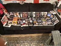 Wide shot of approximately 30 books laid out on a black couch, mostly music and celebrity biographies and memoirs.