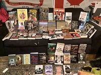 Overview of books arranged on a couch and a rug, showing a variety of biographies, cookbooks, storybooks, and entertainment related titles.