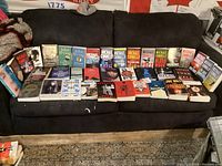 Full wide-angle photo of all books spread on couch, showing arrangement and quantity