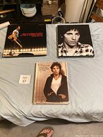 Photo of three vinyl albums with Bruce Springsteen cover art laid on a bed