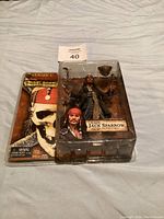 Full view of Captain Jack Sparrow action figure in original blister packaging with backing card showing skull graphic.