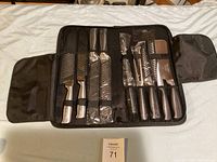 Full view of Ross Henry professional cutting utensil set inside black zippered carrying case, showing multiple knives and kitchen tongs secured with elastic straps