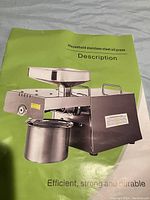 Photo of the product brochure or description page showing the oil press machine with feeding hopper and container.