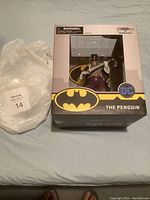 Full view of boxed Penguin figure with bubble wrap beside it