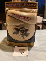 Front of the cheeseburger-shaped locker case packaging for Trailer Park Boys The Complete Collection, featuring image of three main characters.
