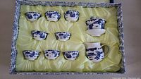 Full set in original box showing 8 cups, teapot, sugar/milk container on saucer arranged in yellow satin lining