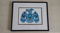 Front view of framed artwork showing black frame and mat with stylized eagle print