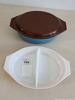 Set showing brown lid on top of blue bowl and white divided plate beneath