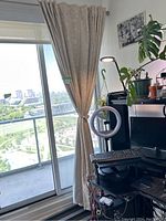 Curtain panel hung on balcony sliding door with city view, gathered by the tieback.