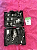 Photo of open black plastic case containing an assortment of drill bits and screwdriver bits organized in molded slots