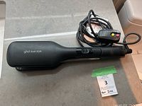 Full view of black GHD Duet Style hair styler on countertop showing flat styling plates and handle.