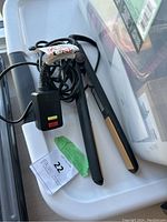 Photo showing the GHD Classic Styler hair straightener with power cord and control box with red and yellow indicators.