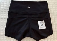 Front view of the black Lululemon shorts showing the logo on the waistband and a small tag attached.