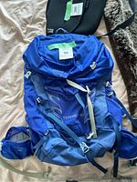 Blue Osprey Tempest 30 hiking backpack laid flat showing front with straps and pockets
