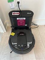 Front view of robot vacuum and self-empty base dock.