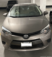 Front view of beige Toyota Corolla in parking garage