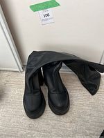 Windsor Smith black boots folded over and placed on floor showing toe and front profile.